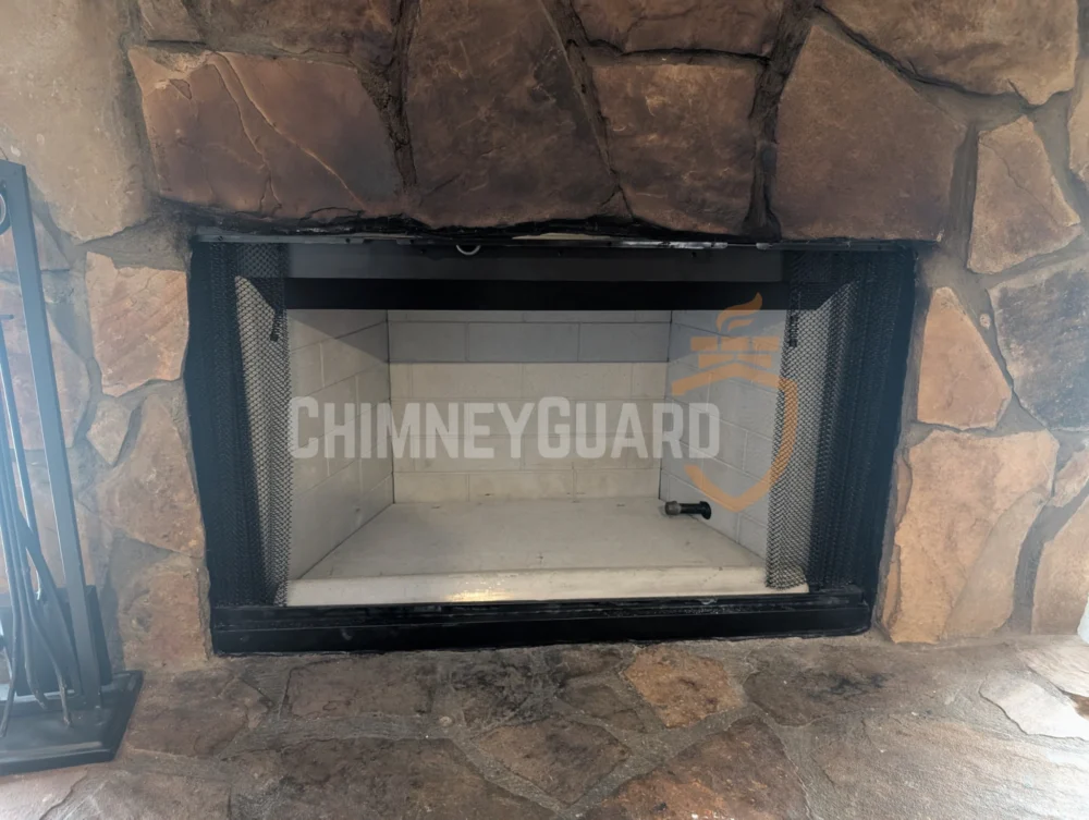 Glass fireplace doors in a natural stone surround